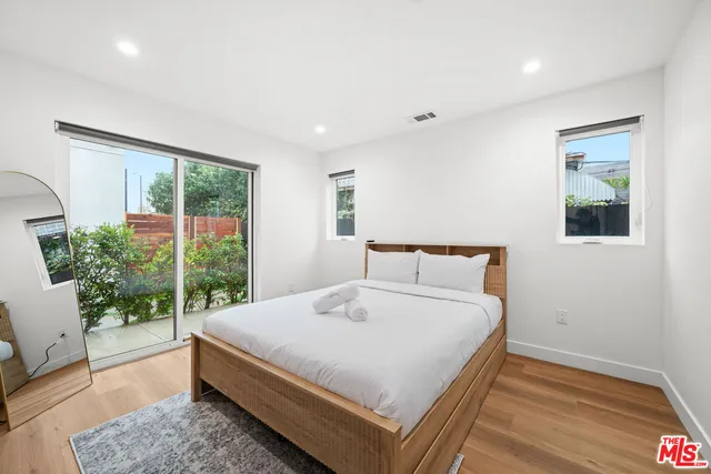 a large bed sitting in a bedroom next to a window