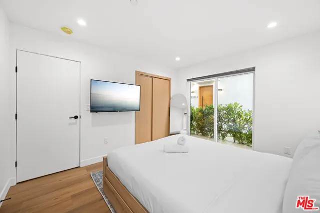 a bedroom with a bed and a flat screen tv