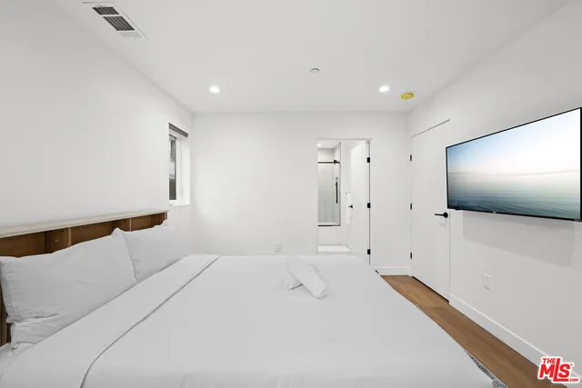 a bedroom with a bed and a flat screen tv