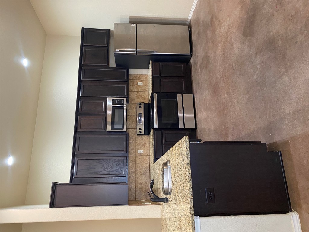 a kitchen with kitchen island granite countertop stainless steel appliances and wooden cabinets