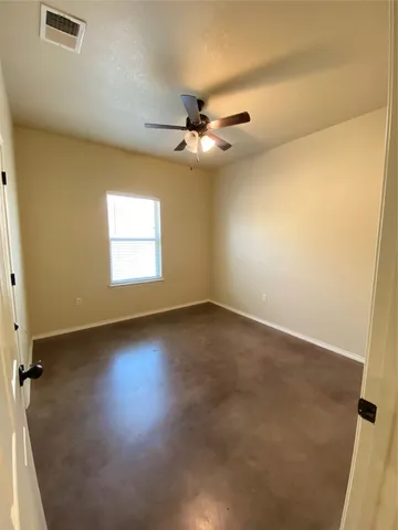 an empty room with a window and ceiling fan