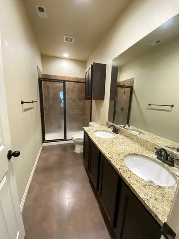 a bathroom with a granite countertop sink a mirror and shower