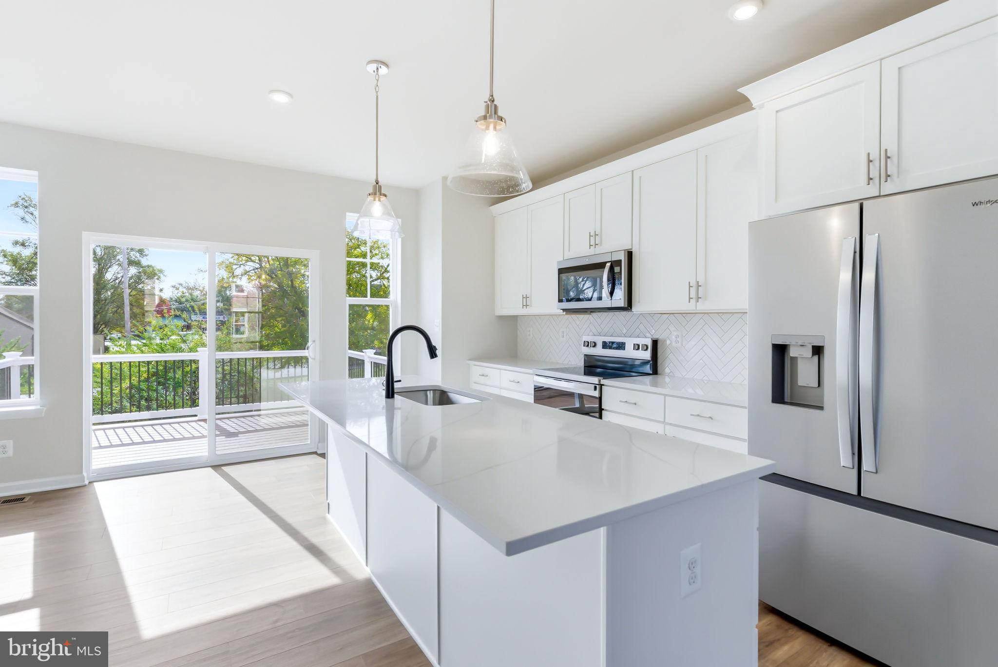 209 Monteith Drive Winchester, VA 22601 - Photo 2 of 29 a kitchen with a refrigerator a stove top oven and a large window