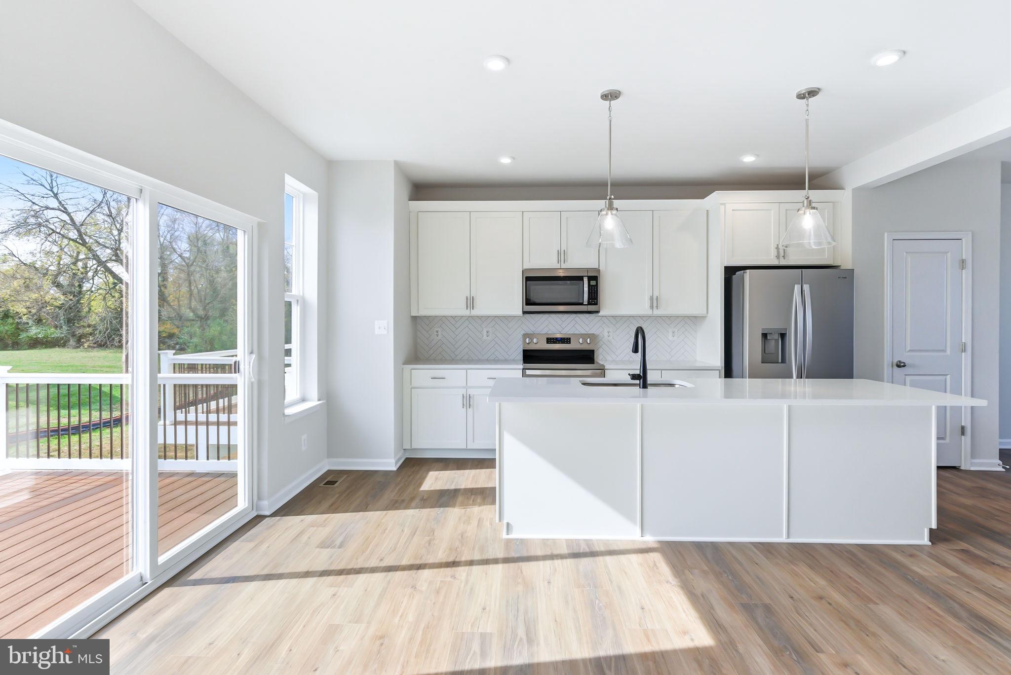209 Monteith Drive Winchester, VA 22601 - Photo 5 of 29 a kitchen with stainless steel appliances kitchen island granite countertop a refrigerator a stove a sink and white cabinets with wooden floor