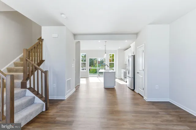 a view of entryway and hall with wooden floor