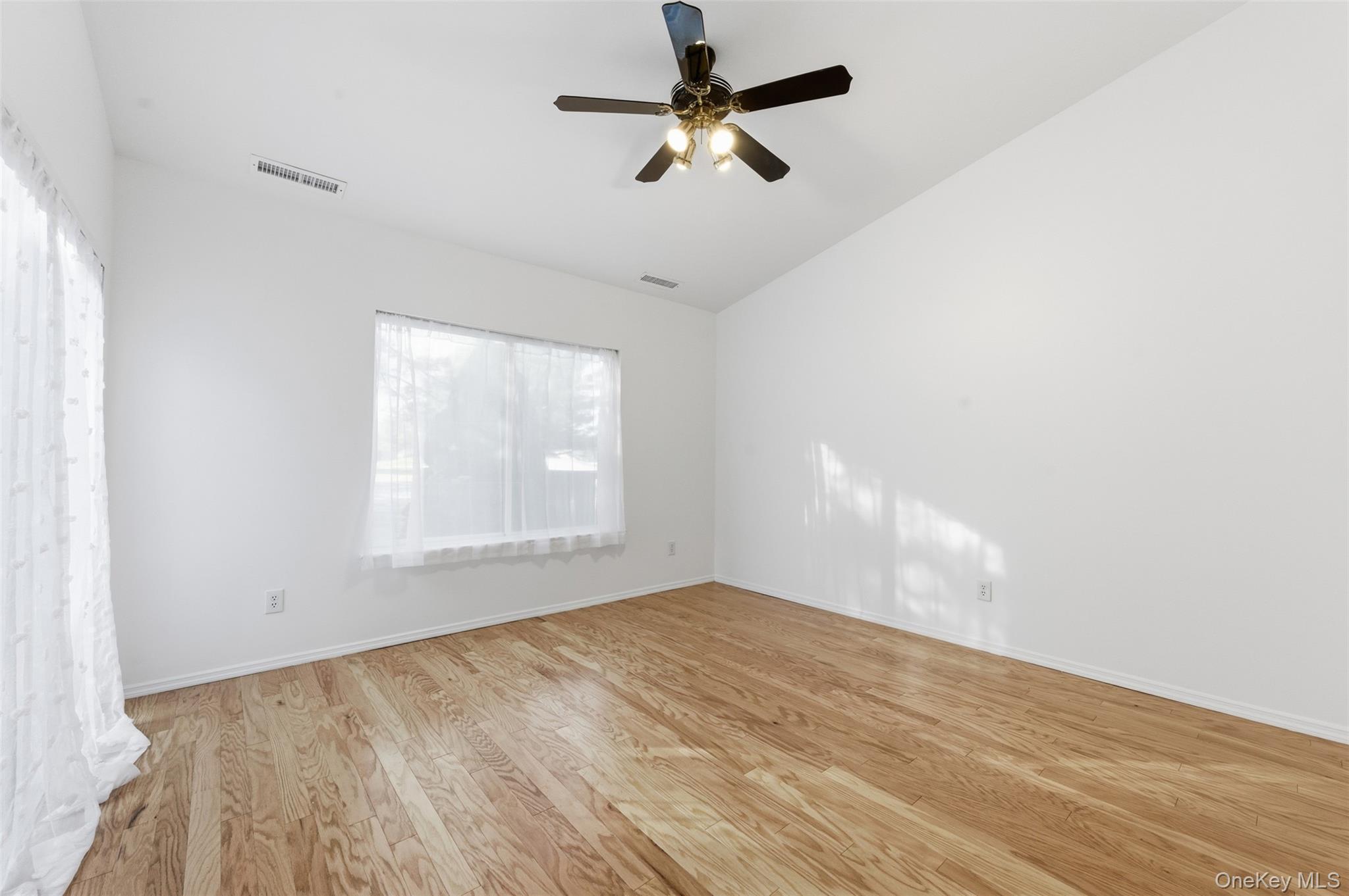 763 Spring Lake Drive Middle Island, NY 11953 - Photo 26 of 31 an empty room with a window and a fan