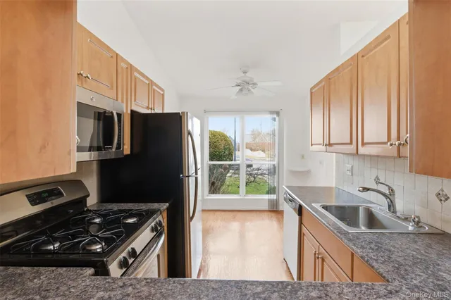 a kitchen that has a sink a stove and a refrigerator