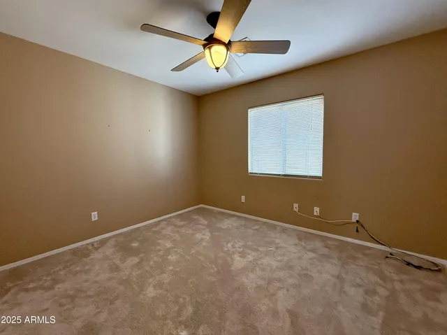 an empty room and a fan & windows