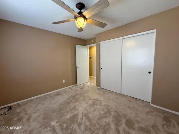 an empty room with a window and a ceiling fan