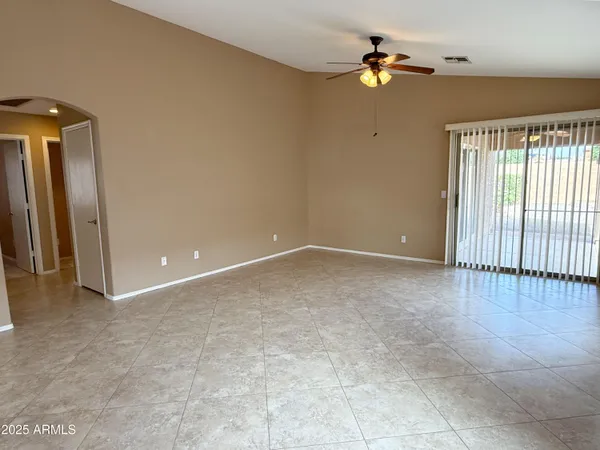 en empty room with windows and ceiling fan