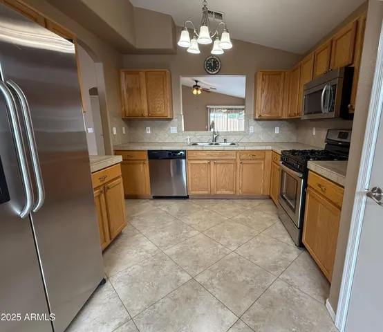 a kitchen with stainless steel appliances granite countertop a refrigerator a stove top oven a sink and dishwasher