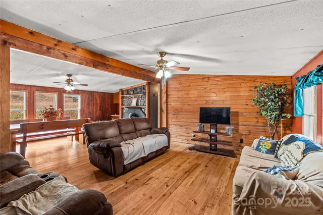 a view of a dining room and livingroom with furniture wooden floor a rug a flat screen tv