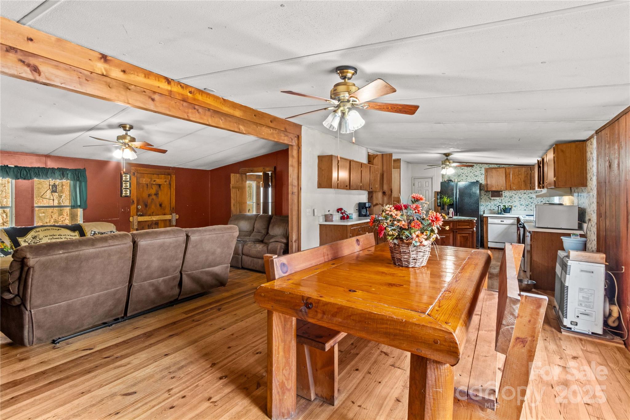 338 Piney Grove Road Harmony, NC 28634 - Photo 21 of 44 a view of a dining room and livingroom with furniture wooden floor a rug a flat screen tv