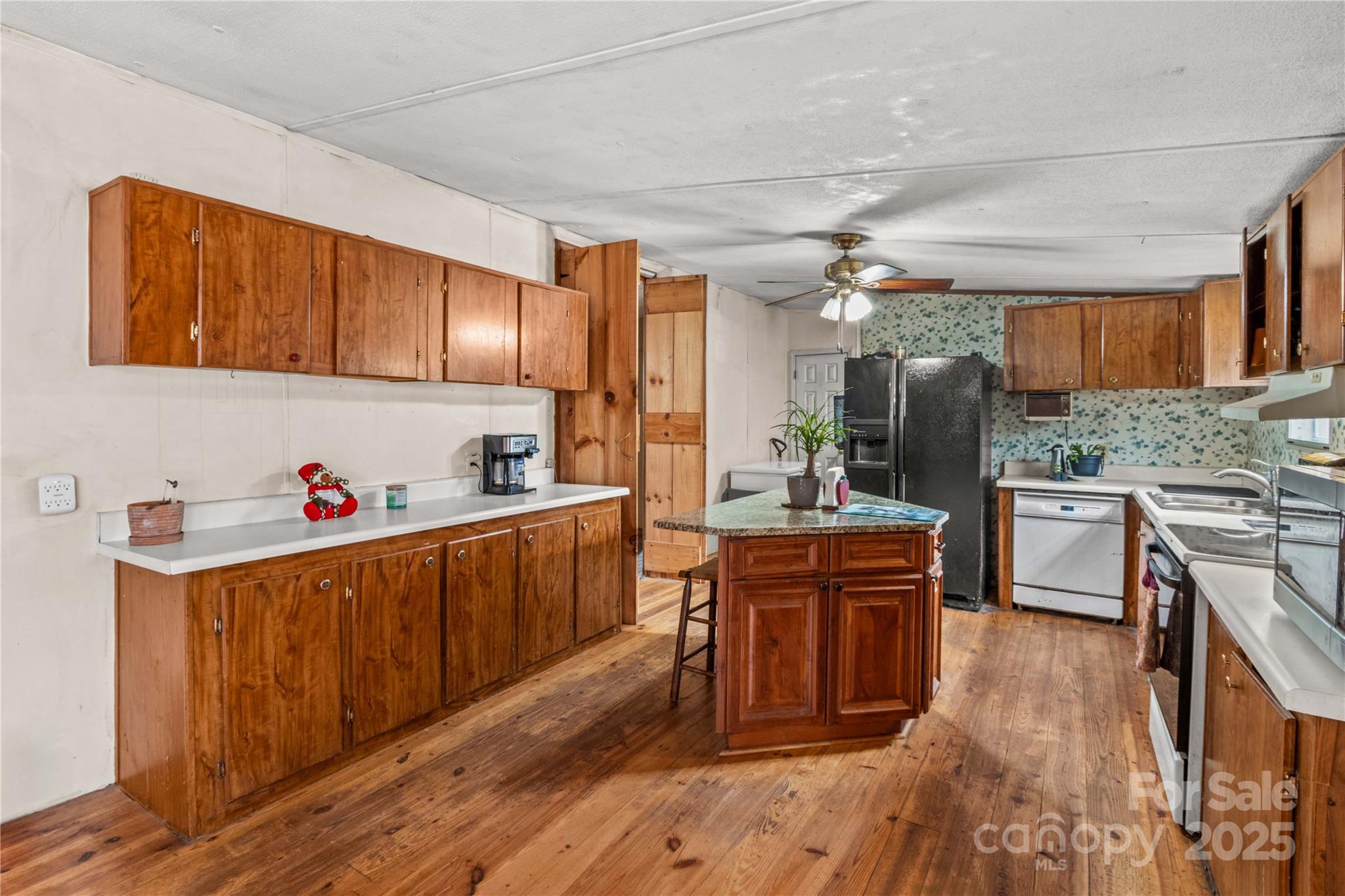 338 Piney Grove Road Harmony, NC 28634 - Photo 23 of 44 a kitchen with wooden cabinets and center island
