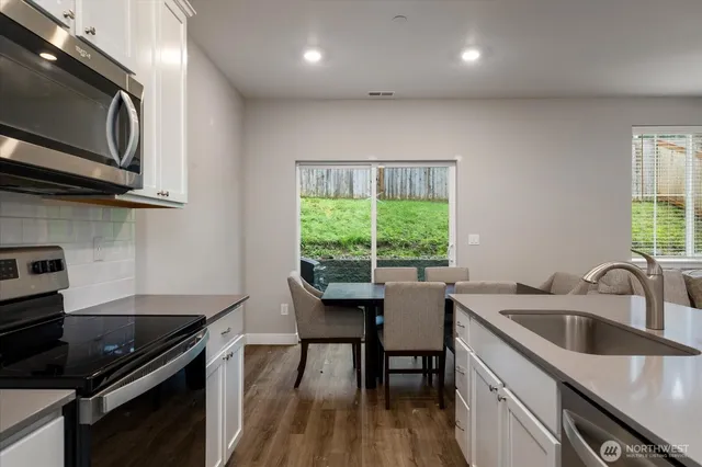 a kitchen with a sink a stove and cabinets