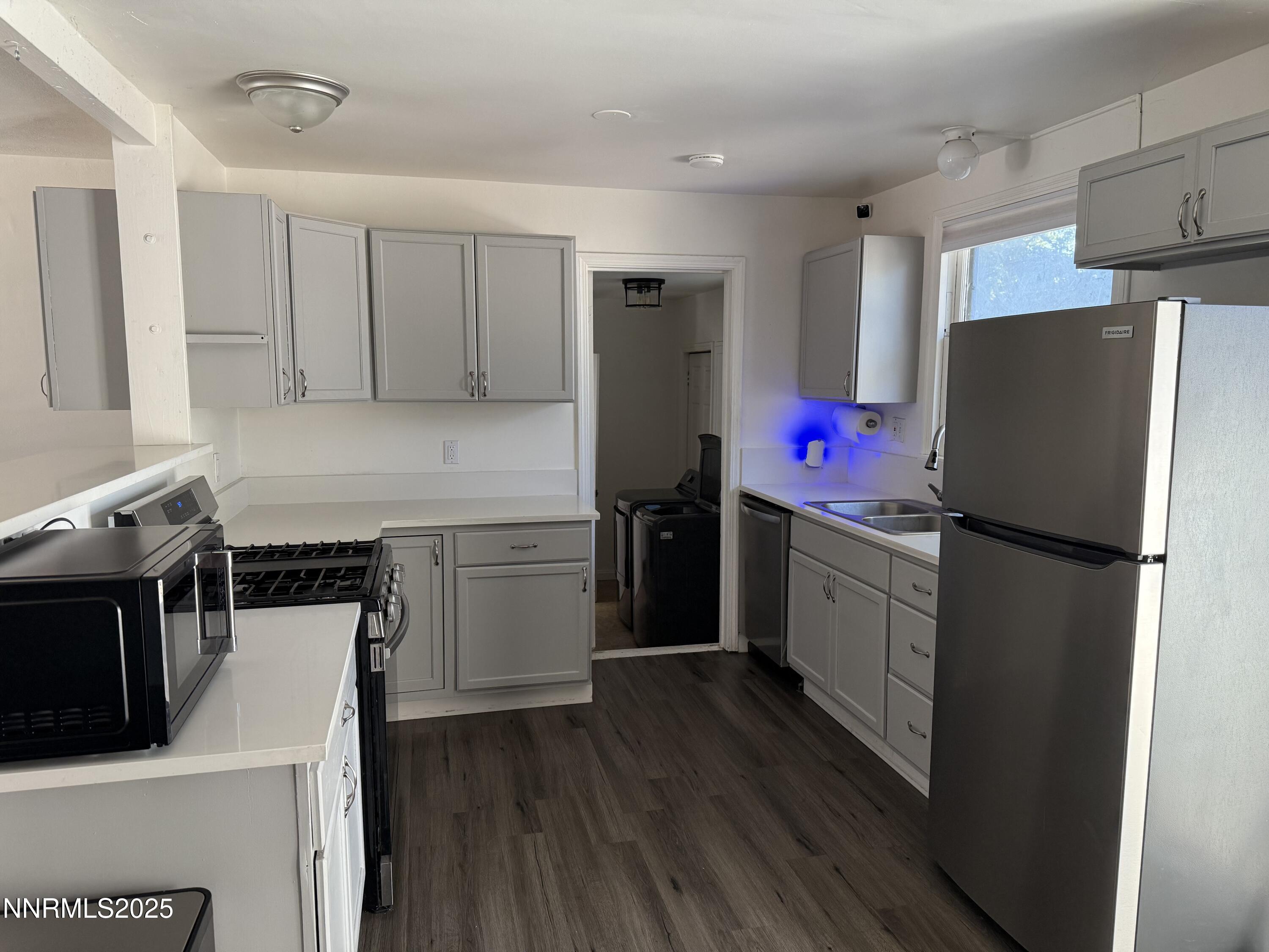 345 H Street Sparks, NV 89431 - Photo 4 of 14 a kitchen with a refrigerator a stove top oven and wooden floor