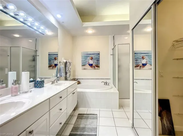 a spacious bathroom with a double vanity sink a mirror and a bathtub