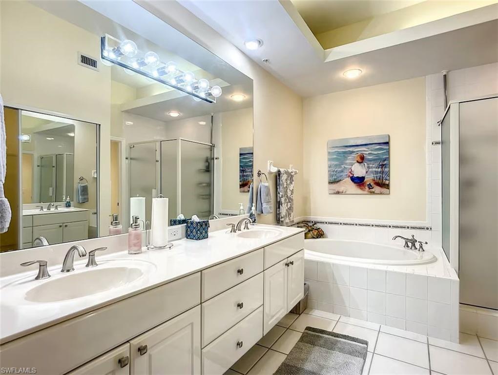 14530 Red Fox Run, Unit 215 Naples, FL 34110 - Photo 12 of 28 a bathroom with a double vanity sink mirror and bathtub