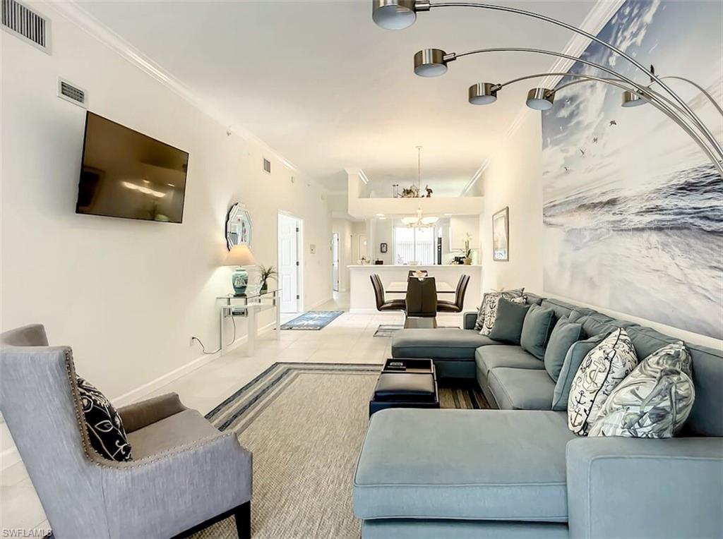 14530 Red Fox Run, Unit 215 Naples, FL 34110 - Photo 3 of 28 a living room with furniture and a flat screen tv