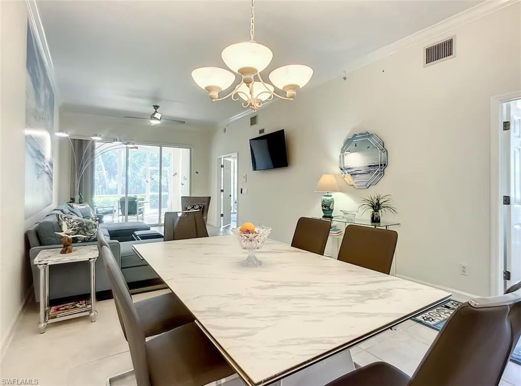 14530 Red Fox Run, Unit 215 Naples, FL 34110 - Photo 7 of 28 a kitchen with a table chairs and a wooden floor