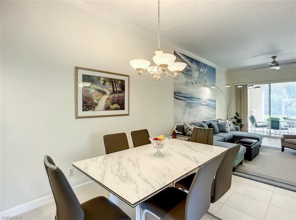 14530 Red Fox Run, Unit 215 Naples, FL 34110 - Photo 8 of 28 a view of a dining room with furniture a chandelier and a window