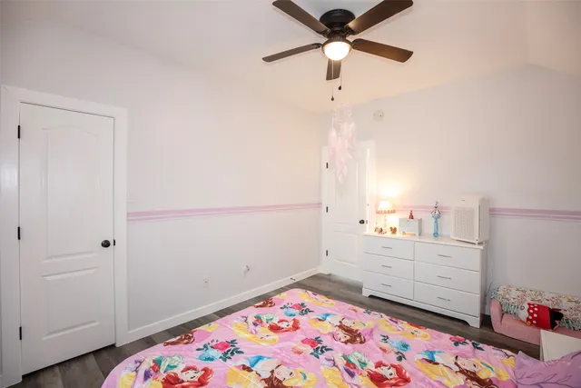 a bedroom with a bed and a chandelier fan