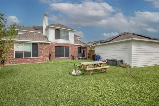 a backyard of a house with table and chairs