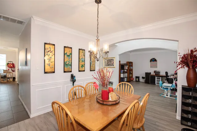 a living room with furniture a flat screen tv and a chandelier