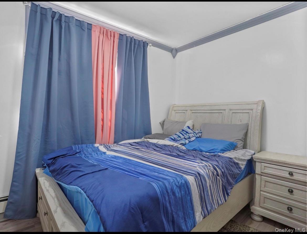 104-55 39th Avenue Queens, NY 11368 - Photo 9 of 14 a bedroom with a bed and a window