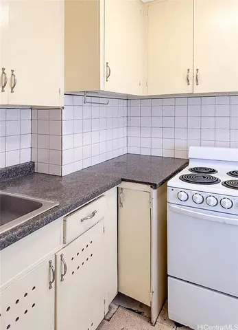 a kitchen with granite countertop white cabinets and white appliances