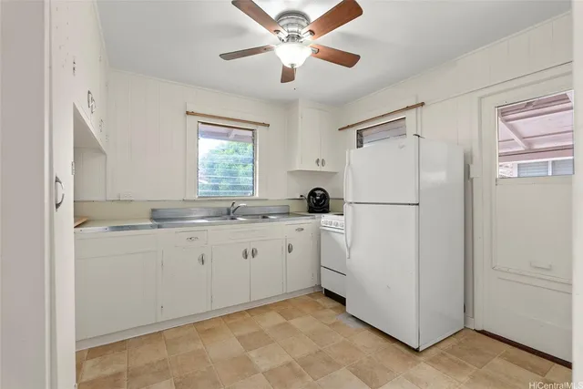 a kitchen with white cabinets and white appliances