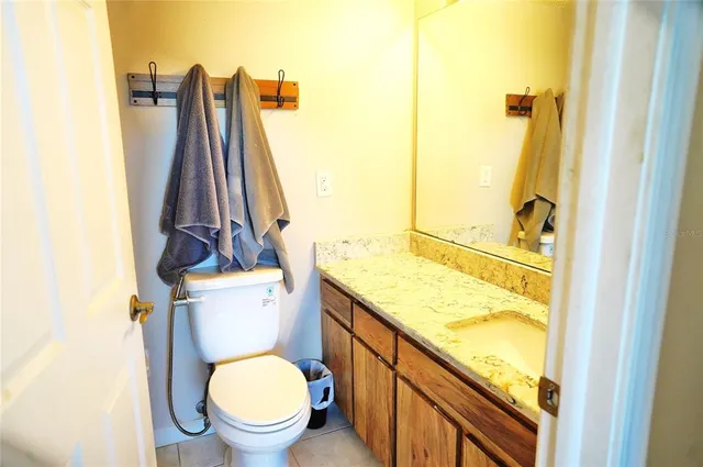 a bathroom with a granite countertop toilet and a sink