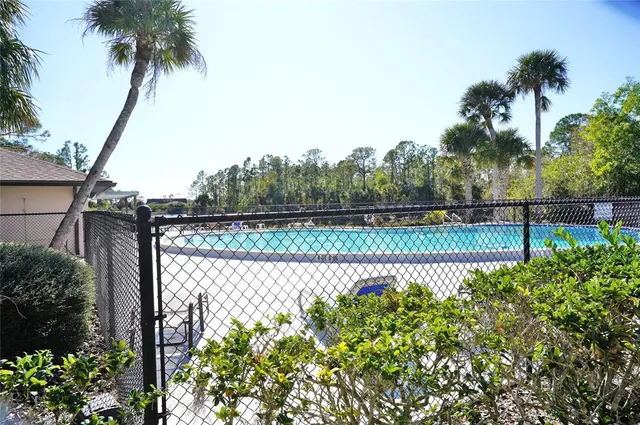 a view of a lake with a big yard and palm trees