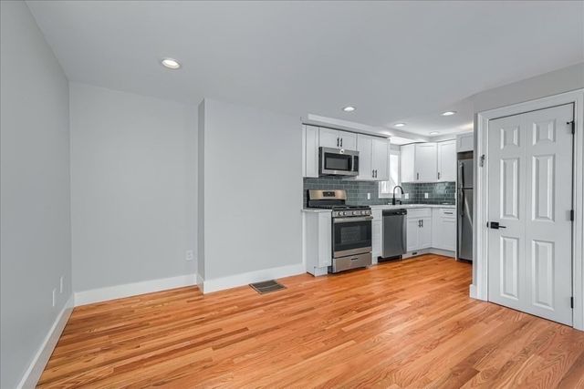 a kitchen with wooden floors and stainless steel appliances