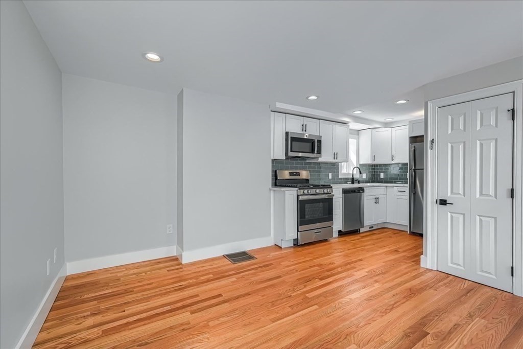 1 Short St Place Boston, MA 02129 - Photo 5 of 21 a kitchen with wooden floors and stainless steel appliances