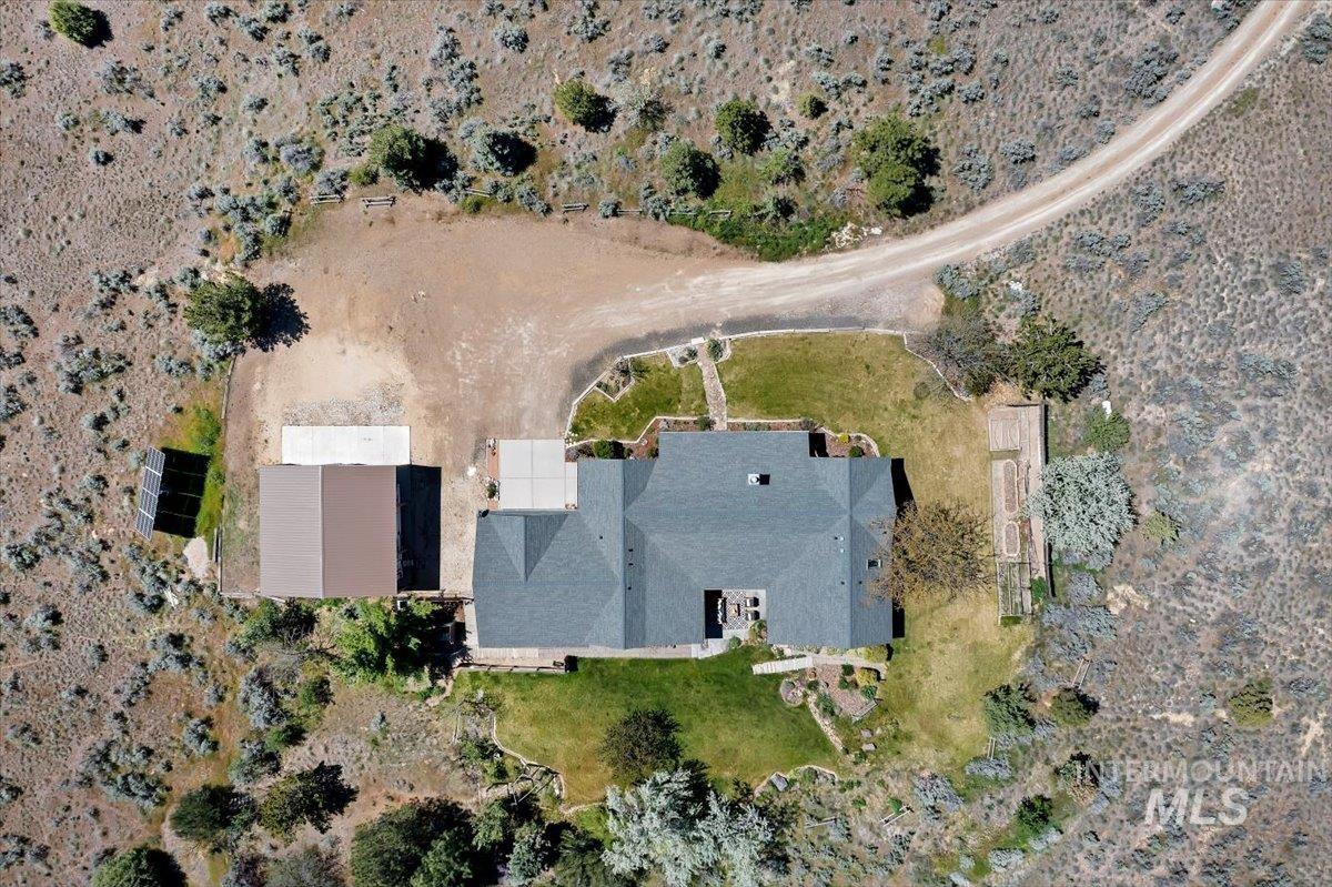 147 East Indian Crk Road Boise, ID 83716 - Photo 5 of 43 Expansive property featuring a grey-shingled roof residence, a large detached outbuilding, a concrete patio, and a gravel driveway