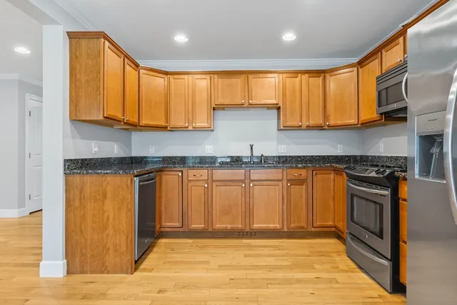 a kitchen with stainless steel appliances granite countertop a stove a sink and a granite counter tops