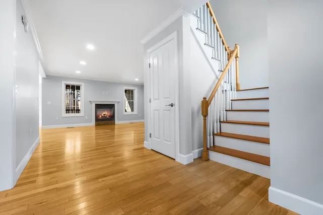 a view of empty room with a fireplace and wooden floor