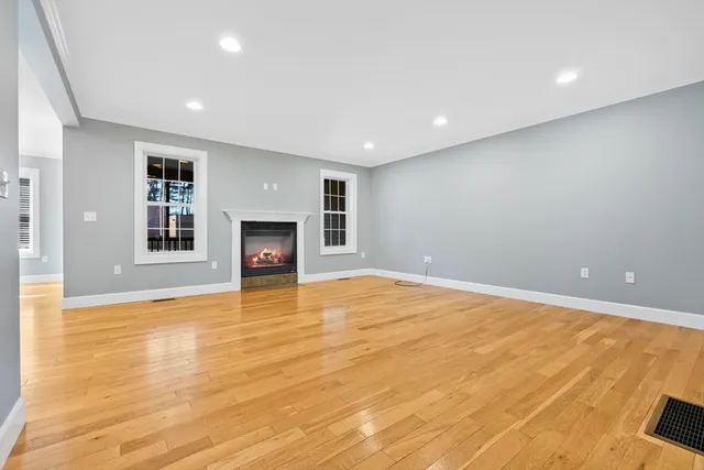 a view of empty room with wooden floor and fireplace