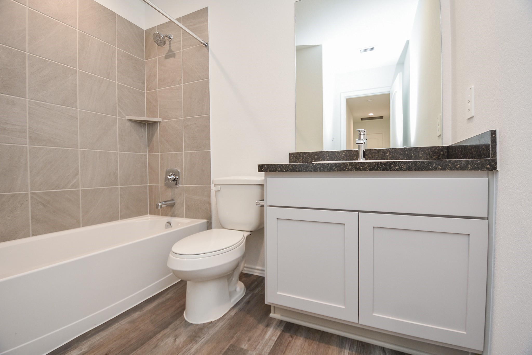 5735 Sycamore Glen Dr Spring Spring, TX 77373 - Photo 19 of 26 a bathroom with a granite countertop toilet a sink and bathtub
