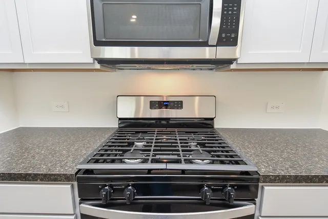 a stove top oven sitting inside of a kitchen