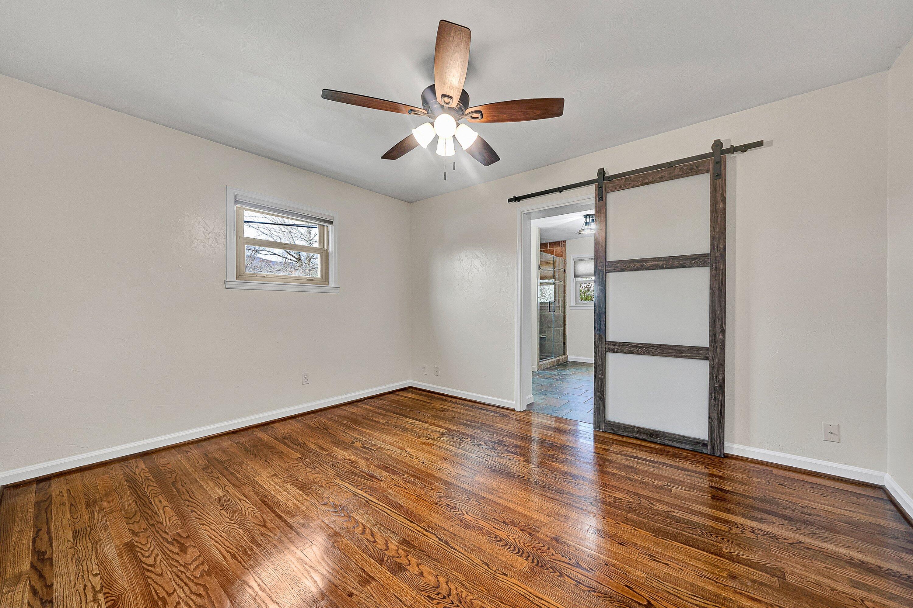 405 Diamond Road Salem, VA 24153 - Photo 12 of 28 an empty room with wooden floor chandelier fan and windows