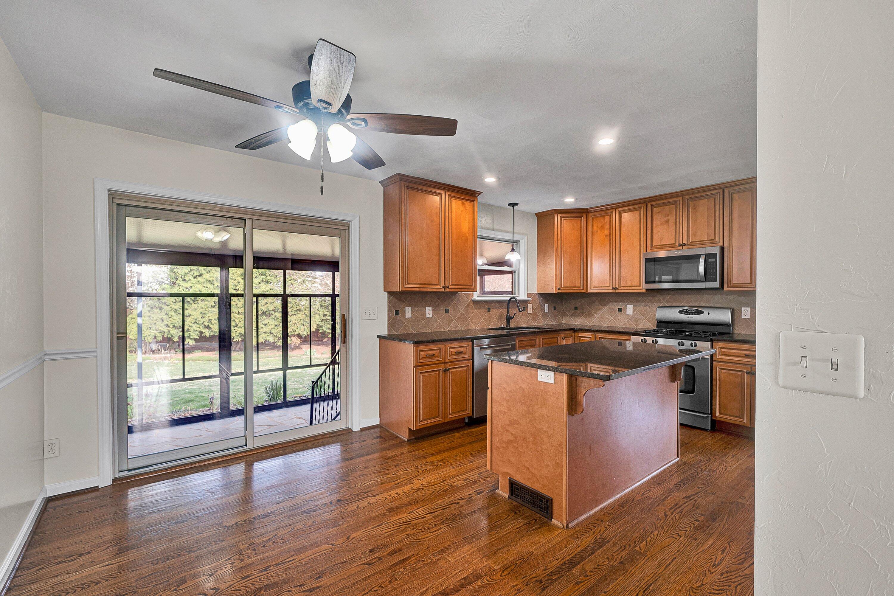 405 Diamond Road Salem, VA 24153 - Photo 6 of 28 a kitchen with stainless steel appliances granite countertop wooden floors and white cabinets