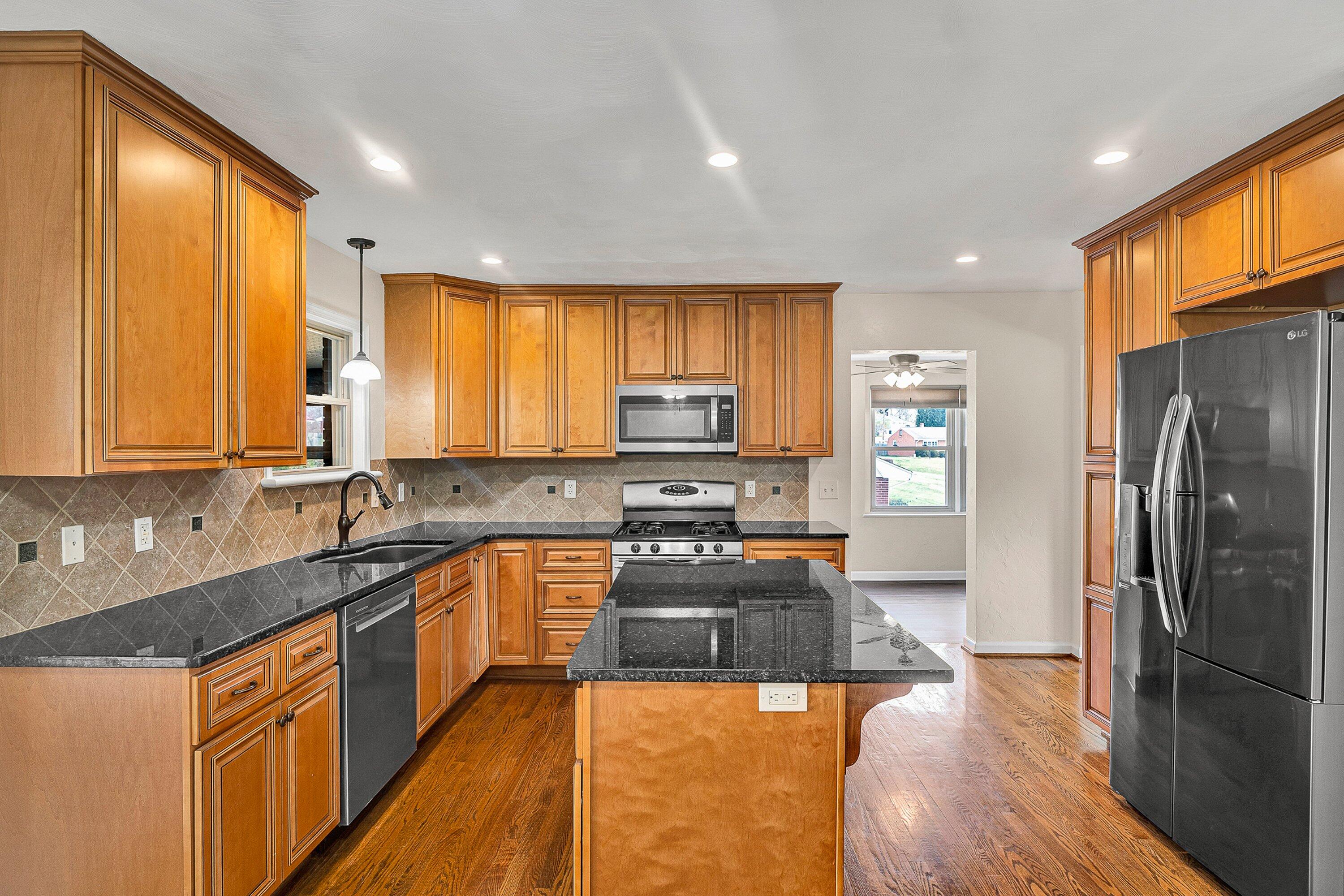 405 Diamond Road Salem, VA 24153 - Photo 7 of 28 a kitchen with stainless steel appliances granite countertop a stove a sink dishwasher a refrigerator and cabinets with wooden floor