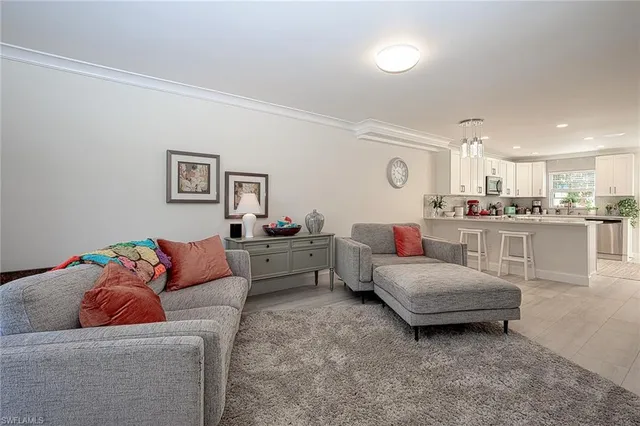 a living room with furniture and kitchen view