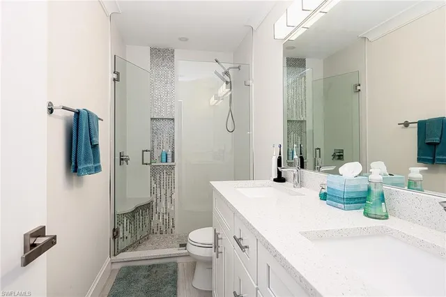 a bathroom with a sink a toilet and shower