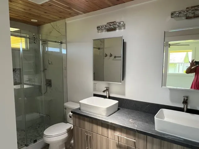 a bathroom with a sink a toilet and shower