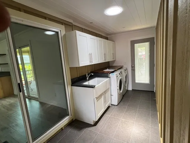 a utility room with cabinets washer and dryer