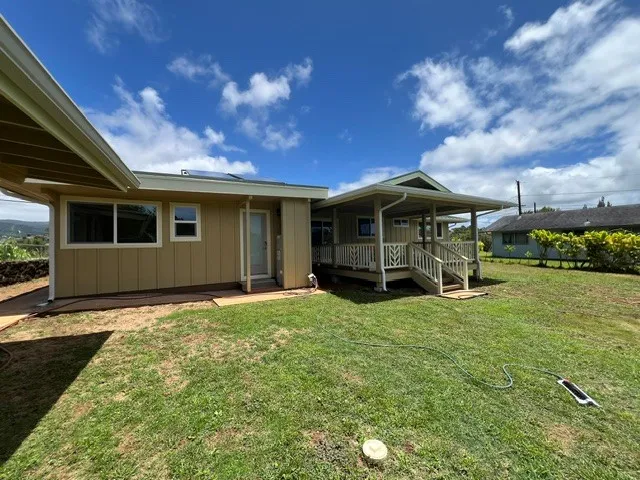 a view of a house with backyard porch and sitting area