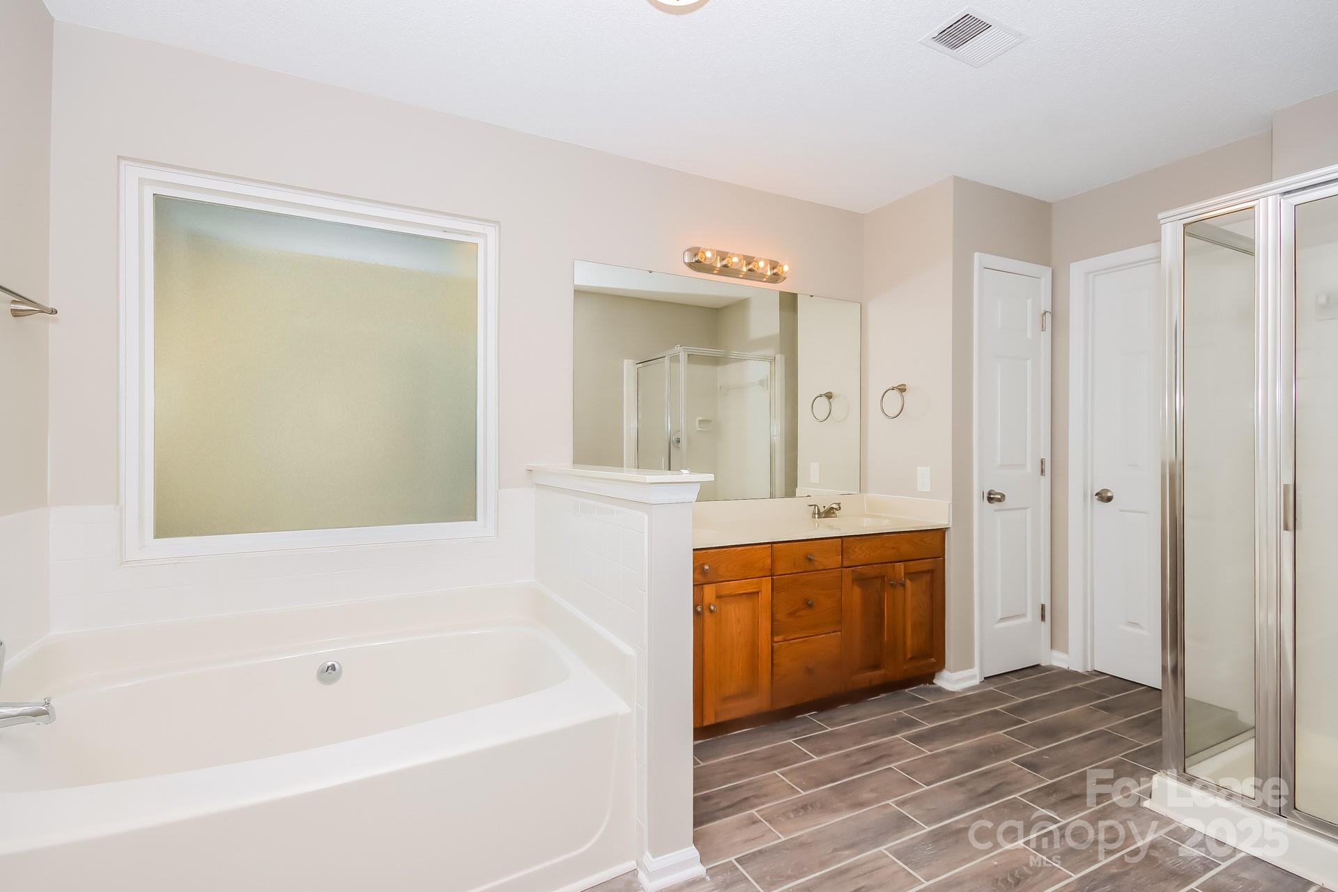 9216 Torrence Crossing Drive Huntersville, NC 28078 - Photo 11 of 17 a bathroom with a tub sink and mirror